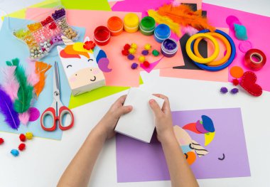 Çocuk el craftwork tek boynuzlu at yapışır. Kağıt kutusu sıradışı hediyesi. Ana sınıfı el yapımı. En sevdiği hobi. Ana ve okulu.