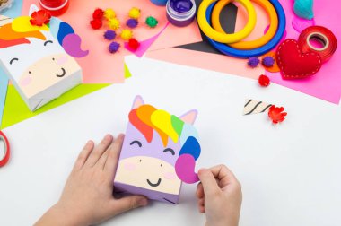 Çocuk el craftwork tek boynuzlu at yapışır. Kağıt kutusu sıradışı hediyesi. Ana sınıfı el yapımı. En sevdiği hobi. Ana ve okulu.