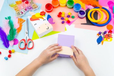 Çocuk el craftwork tek boynuzlu at yapışır. Kağıt kutusu sıradışı hediyesi. Ana sınıfı el yapımı. En sevdiği hobi. Ana ve okulu.