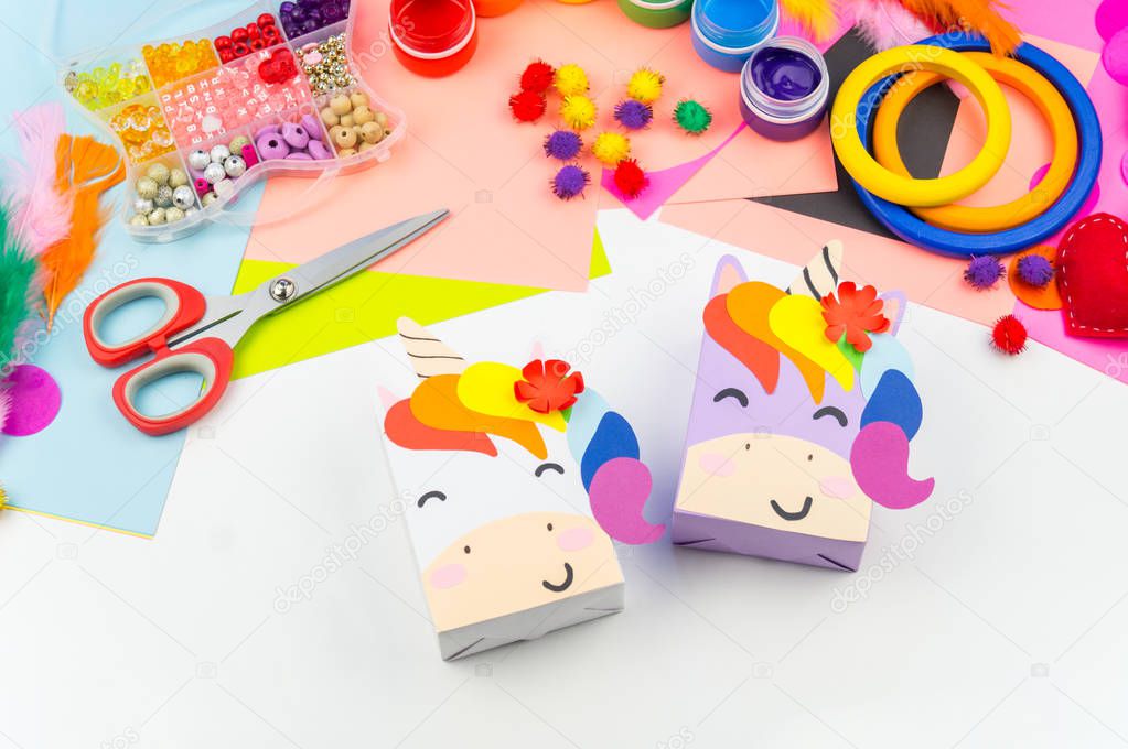 A box with a gift inside in the form of a rainbow unicorn. Children's paper craft school kindergarten. Party with a surprise.