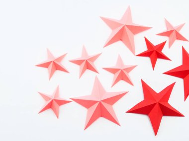 Yıldız kağıt rengi kırmızı pembe yaptı. Festival dekor yıldızlı gökyüzü. Beyaz arka plan. En sevdiği hobi. Yaratıcılık çocuklu.