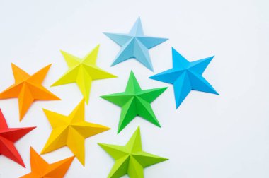 Gökkuşağı renkli kağıttan yapılmış bir yıldız. Festival dekor yıldızlı gökyüzü. Beyaz arka plan. En sevdiği hobi. Yaratıcılık çocuklu.