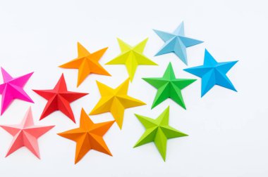 Gökkuşağı renkli kağıttan yapılmış bir yıldız. Festival dekor yıldızlı gökyüzü. Beyaz arka plan. En sevdiği hobi. Yaratıcılık çocuklu.