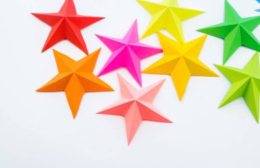 Gökkuşağı renkli kağıttan yapılmış bir yıldız. Festival dekor yıldızlı gökyüzü. Beyaz arka plan. En sevdiği hobi. Yaratıcılık çocuklu.