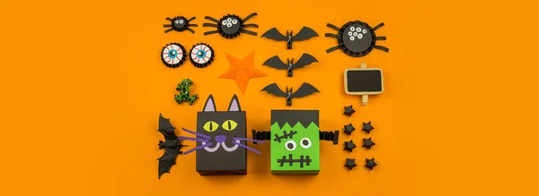 Orange background with collection of Halloween objects overhead view Banner . Black cat, spider, bat, witch, feared party decor. Handwork.