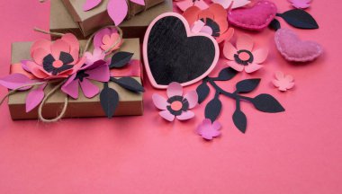 Vintage hediye kutuları Eko kağıt üzerinde pembe bir arka plan. Hediye gül çiçek sakura ve yaprakları ile süslenmiş. Siyah kalp yazmak için. Sevgililer günü veya diğer tatil kavramı, üstten görünüm, düz yatıyordu, havai görünümü