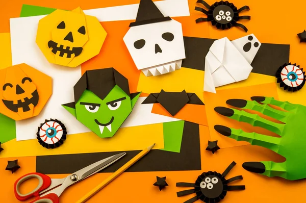 Orange background with collection of Halloween objects overhead view. Skull, pumpkin, ghost, monster, green hand, spider, bat, witch, feared party decor. Handwork.