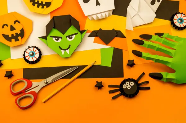 Orange background with collection of Halloween objects overhead view. Skull, pumpkin, ghost, monster, green hand, spider, bat, witch, feared party decor. Handwork.
