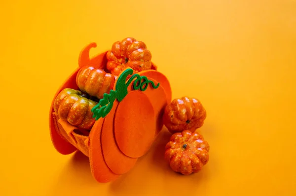 塑料南瓜躺在一个袋子橙色的背景 丰收节 很多万圣节的装饰 — 图库照片