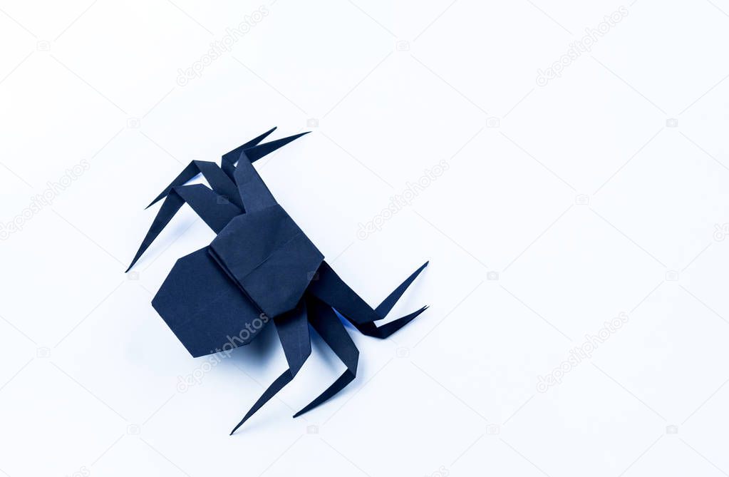 Origami Halloween. Black spider made of paper. Copy space