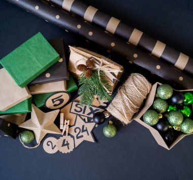 Hediye çantaları ve şeker dolu kutular ile Advent takvim. Noel dekoru. Hediye ambalaj Kraft kağıt. Siyah arka plan.