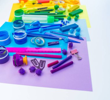 Okul aksesuarları bir gökkuşağı şeklinde yerleştirilir. Beyaz arka plan. Geri okul öğrenci için çok mutluyum. Sanat ve el sanatları çocuklar için. Gökkuşağı renkleri, alfabe harfler ve sayılar öğrenme çocuk.