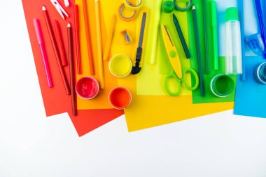 Okul aksesuarları bir gökkuşağı şeklinde yerleştirilir. Beyaz arka plan. Geri okul öğrenci için çok mutluyum. Sanat ve el sanatları çocuklar için. Gökkuşağı renkleri, alfabe harfler ve sayılar öğrenme çocuk.