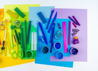 Okul aksesuarları bir gökkuşağı şeklinde yerleştirilir. Beyaz arka plan. Geri okul öğrenci için çok mutluyum. Sanat ve el sanatları çocuklar için. Gökkuşağı renkleri, alfabe harfler ve sayılar öğrenme çocuk.