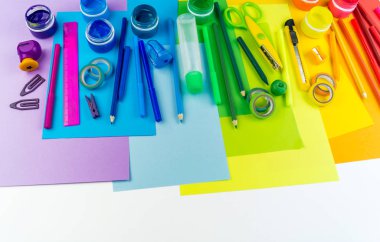 Okul aksesuarları bir gökkuşağı şeklinde yerleştirilir. Beyaz arka plan. Geri okul öğrenci için çok mutluyum. Sanat ve el sanatları çocuklar için. Gökkuşağı renkleri, alfabe harfler ve sayılar öğrenme çocuk.