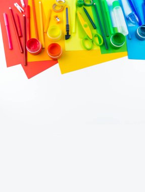 Okul aksesuarları bir gökkuşağı şeklinde yerleştirilir. Beyaz arka plan. Geri okul öğrenci için çok mutluyum. Sanat ve el sanatları çocuklar için. Gökkuşağı renkleri, alfabe harfler ve sayılar öğrenme çocuk.