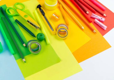 Okul aksesuarları bir gökkuşağı şeklinde yerleştirilir. Beyaz arka plan. Geri okul öğrenci için çok mutluyum. Sanat ve el sanatları çocuklar için. Gökkuşağı renkleri, alfabe harfler ve sayılar öğrenme çocuk.