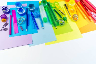 Okul aksesuarları bir gökkuşağı şeklinde yerleştirilir. Beyaz arka plan. Geri okul öğrenci için çok mutluyum. Sanat ve el sanatları çocuklar için. Gökkuşağı renkleri, alfabe harfler ve sayılar öğrenme çocuk.