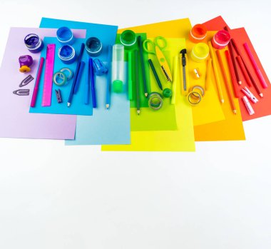 Okul aksesuarları bir gökkuşağı şeklinde yerleştirilir. Beyaz arka plan. Geri okul öğrenci için çok mutluyum. Sanat ve el sanatları çocuklar için. Gökkuşağı renkleri, alfabe harfler ve sayılar öğrenme çocuk.