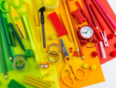 Okul aksesuarları bir gökkuşağı şeklinde yerleştirilir. Beyaz arka plan. Geri okul öğrenci için çok mutluyum. Sanat ve el sanatları çocuklar için. Gökkuşağı renkleri, alfabe harfler ve sayılar öğrenme çocuk.