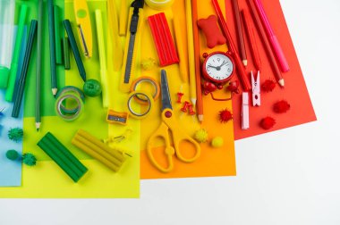 Okul aksesuarları bir gökkuşağı şeklinde yerleştirilir. Beyaz arka plan. Geri okul öğrenci için çok mutluyum. Sanat ve el sanatları çocuklar için. Gökkuşağı renkleri, alfabe harfler ve sayılar öğrenme çocuk.