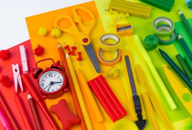 Okul aksesuarları bir gökkuşağı şeklinde yerleştirilir. Beyaz arka plan. Geri okul öğrenci için çok mutluyum. Sanat ve el sanatları çocuklar için. Gökkuşağı renkleri, alfabe harfler ve sayılar öğrenme çocuk.