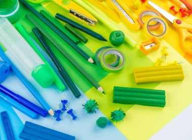 Okul aksesuarları bir gökkuşağı şeklinde yerleştirilir. Beyaz arka plan. Geri okul öğrenci için çok mutluyum. Sanat ve el sanatları çocuklar için. Gökkuşağı renkleri, alfabe harfler ve sayılar öğrenme çocuk.