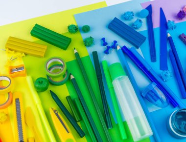 Okul aksesuarları bir gökkuşağı şeklinde yerleştirilir. Beyaz arka plan. Geri okul öğrenci için çok mutluyum. Sanat ve el sanatları çocuklar için. Gökkuşağı renkleri, alfabe harfler ve sayılar öğrenme çocuk.