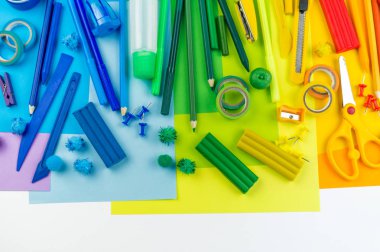 Okul aksesuarları bir gökkuşağı şeklinde yerleştirilir. Beyaz arka plan. Geri okul öğrenci için çok mutluyum. Sanat ve el sanatları çocuklar için. Gökkuşağı renkleri, alfabe harfler ve sayılar öğrenme çocuk.