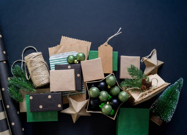 Boxes in eco style with gifts on a black background. Christmas decor. Gift wrapping Kraft paper. Rustic style.