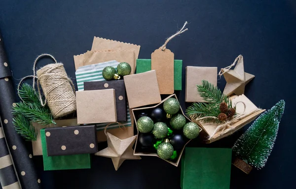 Boxes in eco style with gifts on a black background. Christmas decor. Gift wrapping Kraft paper. Rustic style.