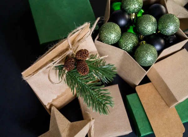 Boxes in eco style with gifts on a black background. Christmas decor. Gift wrapping Kraft paper. Rustic style.