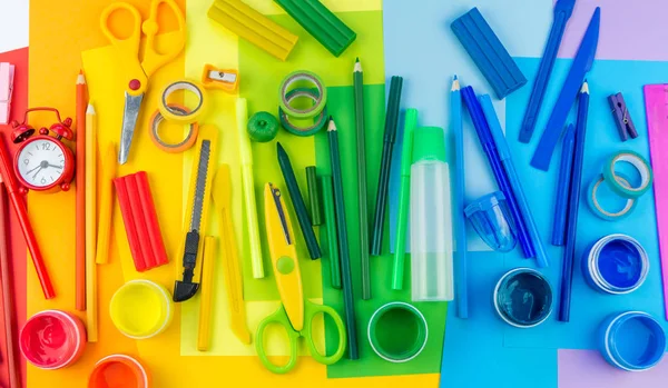 Okul aksesuarları bir gökkuşağı şeklinde yerleştirilir. Beyaz arka plan. Geri okul öğrenci için çok mutluyum. Sanat ve el sanatları çocuklar için. Gökkuşağı renkleri, alfabe harfler ve sayılar öğrenme çocuk.