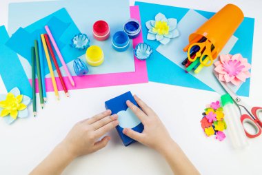 Çocuk elleri kağıttan penguen yapıyor. Çocukların yaratıcılığının uygulanması. Anaokulu ve zanaat okulu. Beyaz arka plan ve el sanatları için malzemeler.