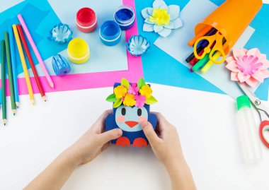 Çocuk elleri kağıttan penguen yapıyor. Çocukların yaratıcılığının uygulanması. Anaokulu ve zanaat okulu. Beyaz arka plan ve el sanatları için malzemeler.