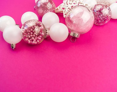 Yumuşak pembe ve beyaz baubles pembe bir arka plan üzerinde. Noel ruh. Festival dekor. Payetler ve bir parti için glitter.