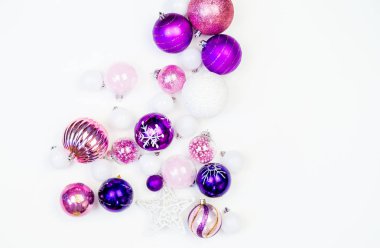 Yumuşak pembe ve mor baubles beyaz zemin üzerinde. Noel ruh. Festival dekor. Payetler ve bir parti için glitter.