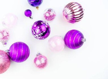 Yumuşak pembe ve mor baubles beyaz zemin üzerinde. Noel ruh. Festival dekor. Payetler ve bir parti için glitter.
