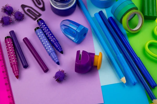 Okul aksesuarları gökkuşağı şeklinde ortaya konur. Siyah arka plan. Okul öğrencisine mutlu. Çocuklar için sanat ve el sanatları. Gökkuşağı renkleri, alfabe harfleri ve sayıları öğrenen çocuk.