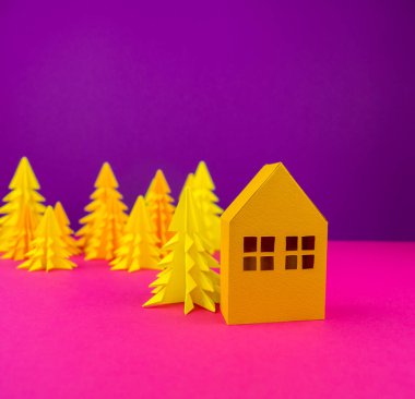 Noel ağacı ve ev sarı tekne kağıttan yapılmış. El sanatları. Mor ve pembe arka plan. Orman