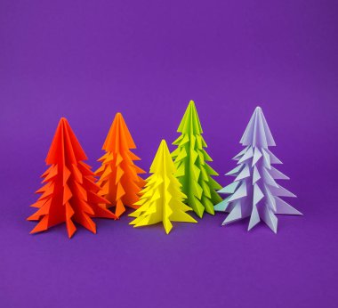 Noel ağacı gökkuşağı zanaat kağıttan yapılmış. El sanatları. Menekşe arka plan. Orman origami
