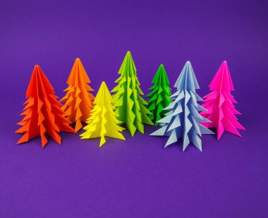 Noel ağacı gökkuşağı zanaat kağıttan yapılmış. El sanatları. Menekşe arka plan. Orman origami
