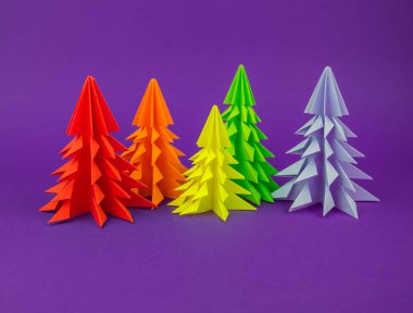 Noel ağacı gökkuşağı zanaat kağıttan yapılmış. El sanatları. Menekşe arka plan. Orman origami