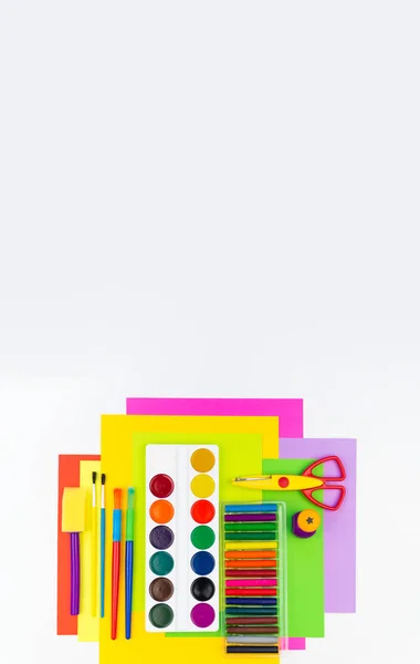 School accessories are laid out in the form of a rainbow. white background. Happy back to school student. Art and crafts for kids. Child learning rainbow colors, alphabet letters and numbers.