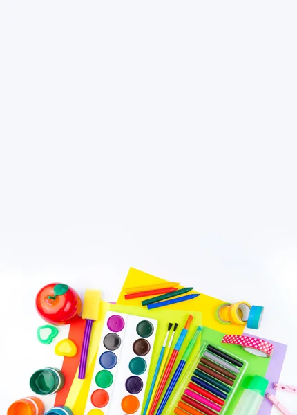 School accessories are laid out in the form of a rainbow. white background. Happy back to school student. Art and crafts for kids. Child learning rainbow colors, alphabet letters and numbers.