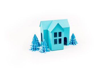 Mavi Ev kağıdımız yapıştırılmış menekşe ormanda duruyor. Beyaz arka plan. Çocuk el sanatları. Noel ağacı.