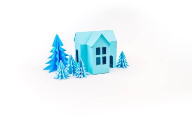 Mavi Ev kağıdımız yapıştırılmış menekşe ormanda duruyor. Beyaz arka plan. Çocuk el sanatları. Noel ağacı.