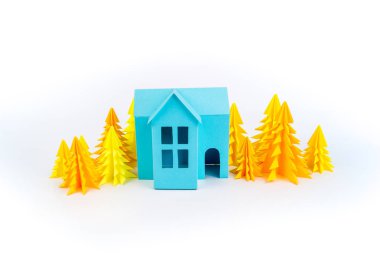 Mavi Ev kağıdımız yapıştırılmış sarı ormanda duruyor. Beyaz arka plan. Çocuk el sanatları. Noel ağacı.