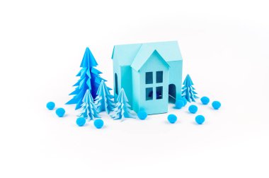 Mavi Ev kağıdımız yapıştırılmış menekşe ormanda duruyor. Beyaz arka plan. Çocuk el sanatları. Noel ağacı. Kartopu ve kar tanesi