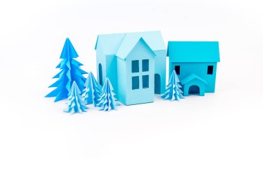 Mavi Ev kağıdımız yapıştırılmış menekşe ormanda duruyor. Beyaz arka plan. Çocuk el sanatları. Noel ağacı.